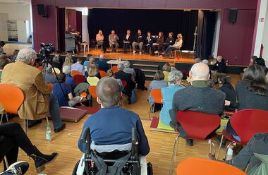 Das Bild zeigt das Plenum in der Montessori-Schule Dachau, wo die Vorträge und Podiumsdiskussionen stattgefunden haben.